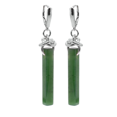 These jade drop earrings have long, thin rectangle shaped hangs made from jade. The jade is attached to the hooks using sterling silver hoops and there are extra hoops linked through them.