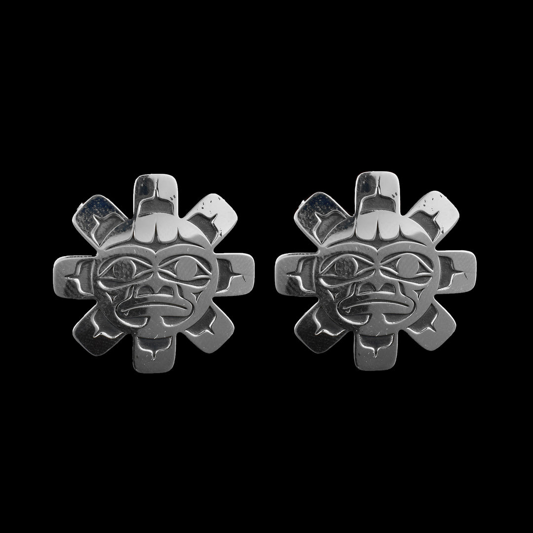 These Sun stud earrings are made from sterling silver and have large, Sun shaped studs. The studs are round and have rounded knobs extending out to imitate sun rays. The face of the Sun is detailed on the studs and shows eyebrow, eye, nose and mouth details.