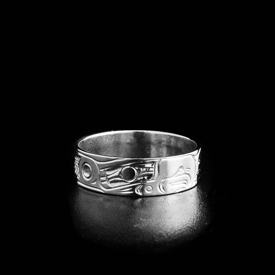 This silver ring depicts the head of an eagle facing the right towards the head of a salmon.