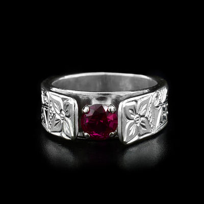 This wolf ring is a classic solitaire ring with a red stone in a silver setting in the center with two flowers carved on both sides of the stone. On the sides of the band are the heads of two wolves facing towards the center.