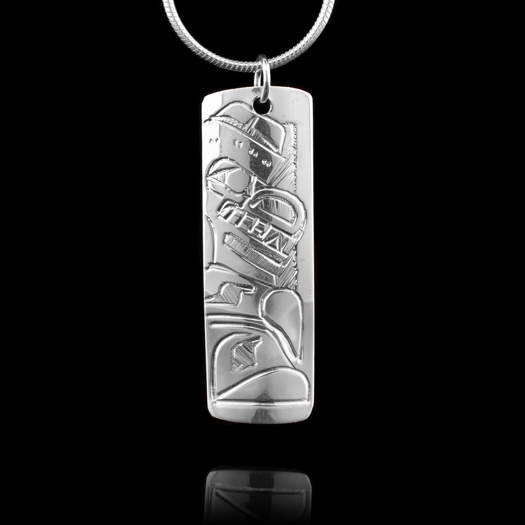 This sterling silver pendant is a small rectangle. There is a depiction of the Bear and a depiction of the Salmon carved onto to either side of this double sided, carved pendant.