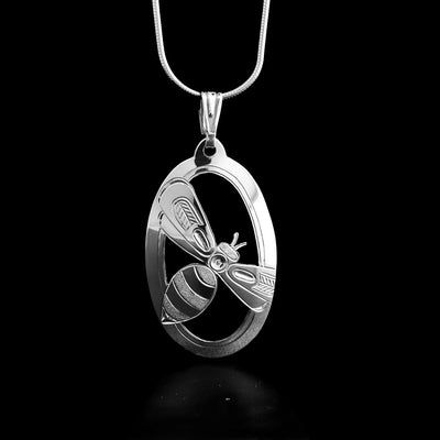 This sterling silver pendant has an oval shape with a bee carved on it.