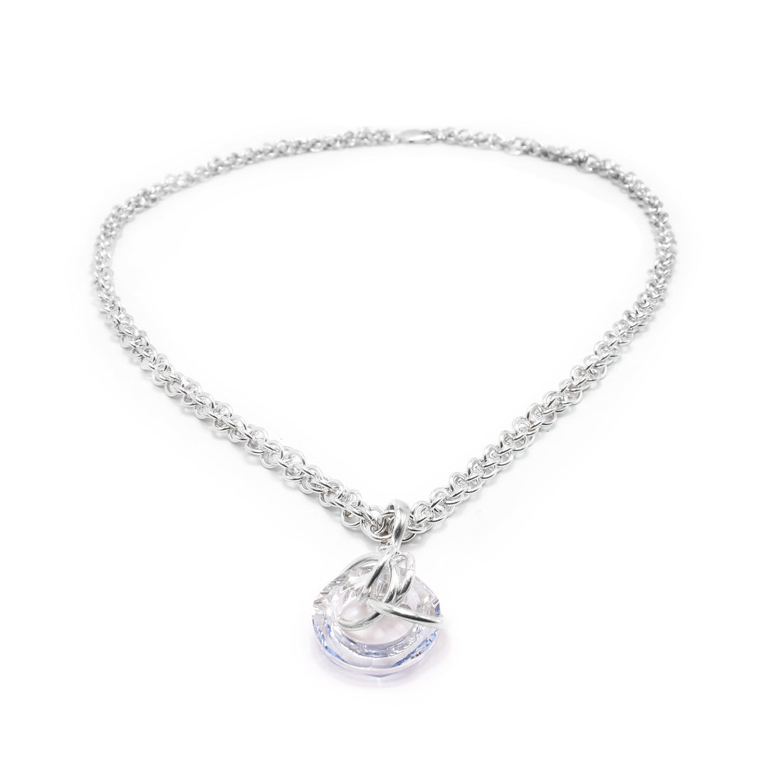 This crystal drop pendant has a hoop shaped blue shade Swarovski crystal. The crystal dangles from a small, sterling silver link with four other large links linked through the crystal pendant.