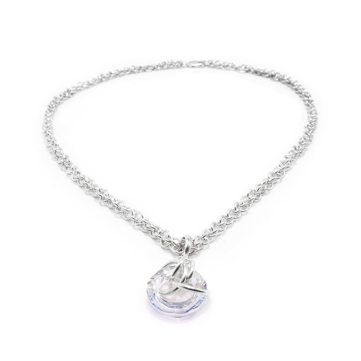 This crystal drop pendant has a hoop shaped blue shade Swarovski crystal. The crystal dangles from a small, sterling silver link with four other large links linked through the crystal pendant.