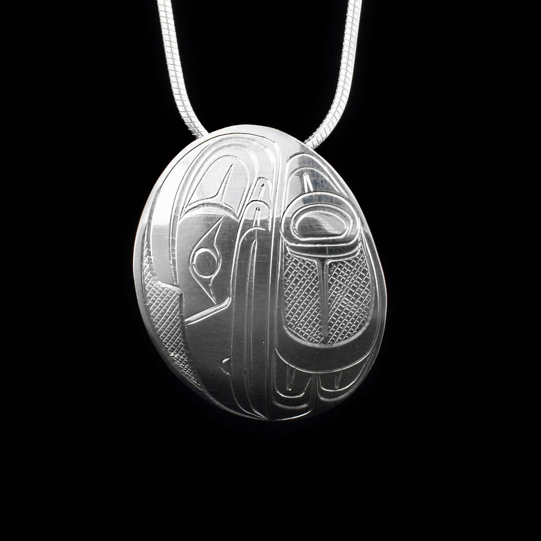 This sterling silver Raven pendant is oval shaped and is carved to depict the Raven.