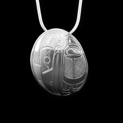 This sterling silver pendant is oval shaped and is carved to depict the Raven.