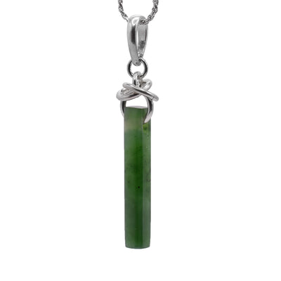 This jade drop pendant has a long, thin rectangle shaped jade piece that dangles from sterling silver hoops. There are extra hoops linked through them at the top of the jade piece.
