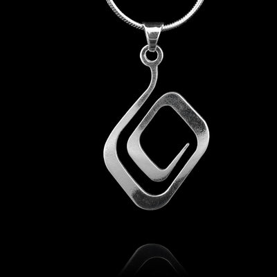 These sterling silver pendants loop around into a round, spiral shape. The piece is made up of a thin, silver piece. The piece depicts a Haida Gwaii character.