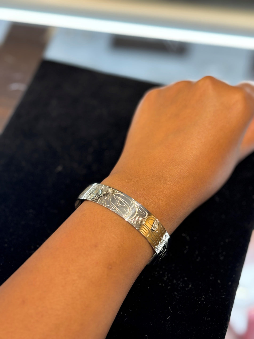 The photo shows a model's hand and wrist while wearing the piece.