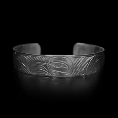 This Eagle cuff bracelet is made form sterling silver and has a depiction of the Eagle carved into the band. The head of the legend is featured in the center of the piece and its wings are outstretched across it.