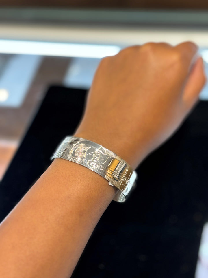 The photo shows a close up of the model's wrist and hand wearing the piece.