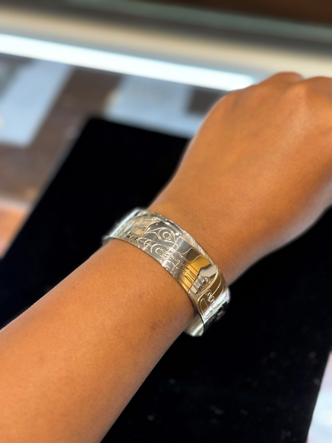 The photo shows a close up of the models wrist and hand while wearing the piece.