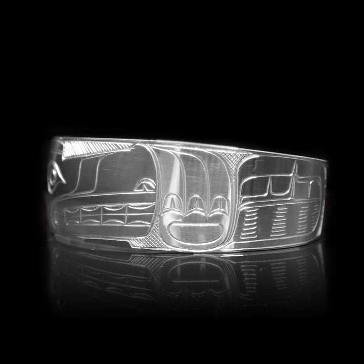 This sterling silver cuff bracelet has a wide band with a depiction of the Wolf carved into the surface of it.