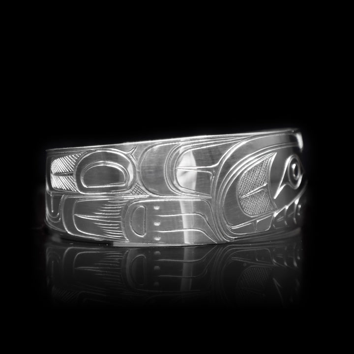 This sterling silver cuff bracelet has a wide band with a depiction of the Wolf carved into the surface of it.