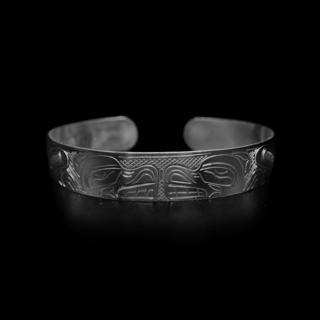 This large Bear bracelet cuff has a sterling silver band with a gap in the back. There are two depictions of the Bear carved into the band. The heads meet in the center of the band and their bodies are depicted on either side of the band.