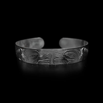 This large Bear bracelet cuff ahs a sterling silver band with a gap in the back. there are depictions of the Bear legend facing each other carved into the band.