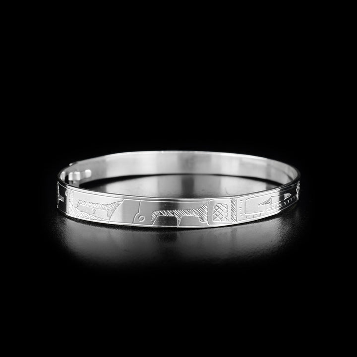 This Orca bracelet is made from sterling silver. The bracelet has a thin band with two depictions of the Orca carved into the surface of it.
