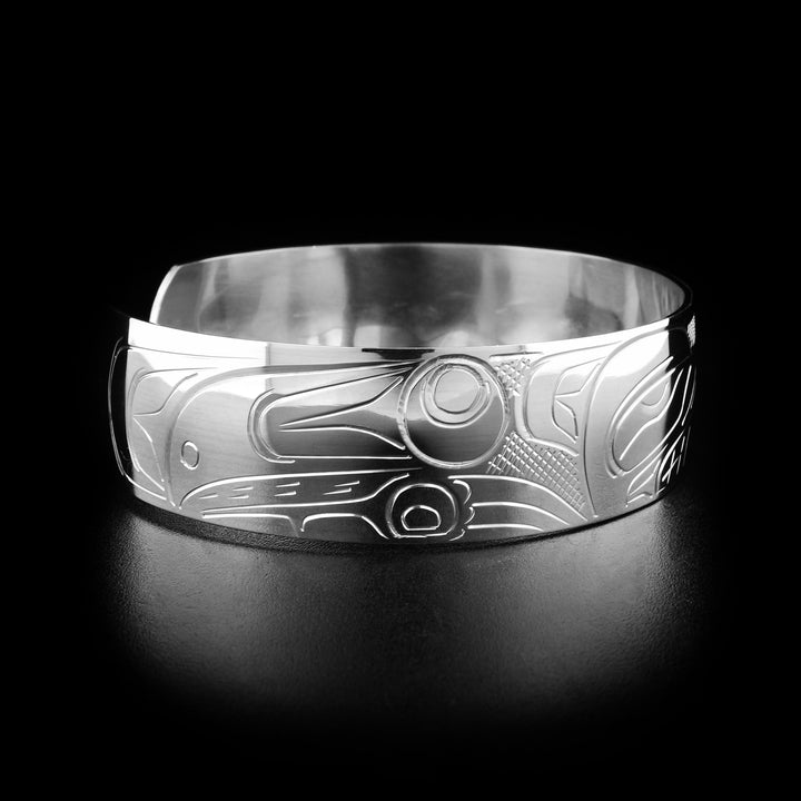 Left angle photo of the bracelet shows carved designs representing the body and paws of the bear.