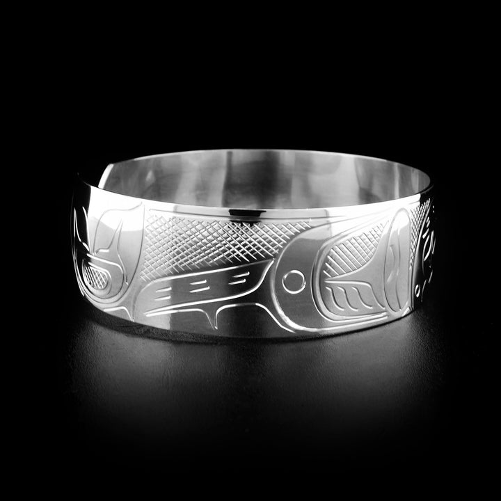 Left angle photo of the bracelet shows carved designs representing the fins and long tail of the orca.