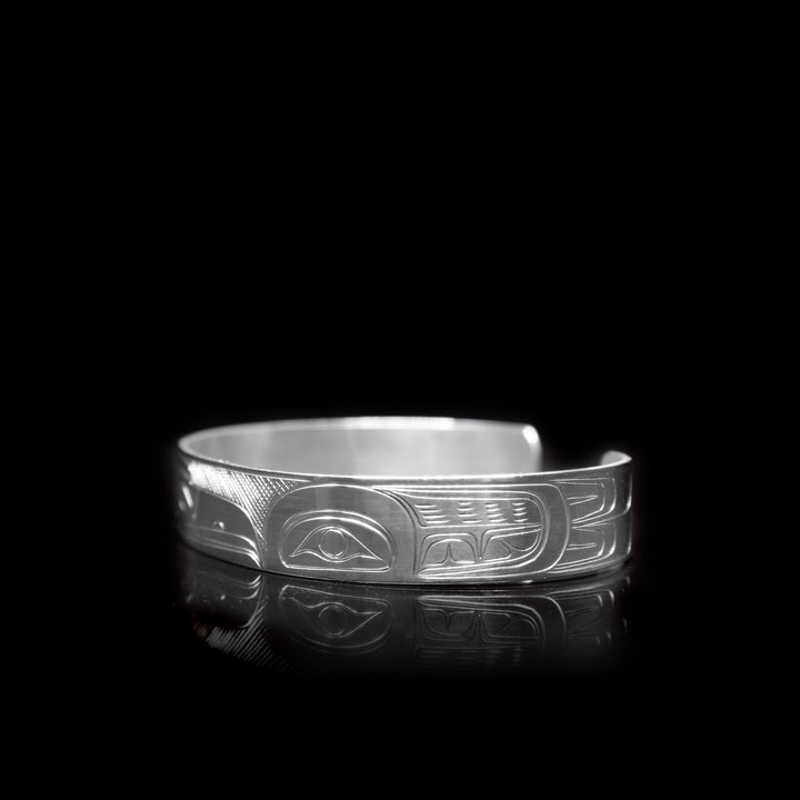 This sterling silver cuff bracelet has a depiction of the Raven carved into the surface of it.
