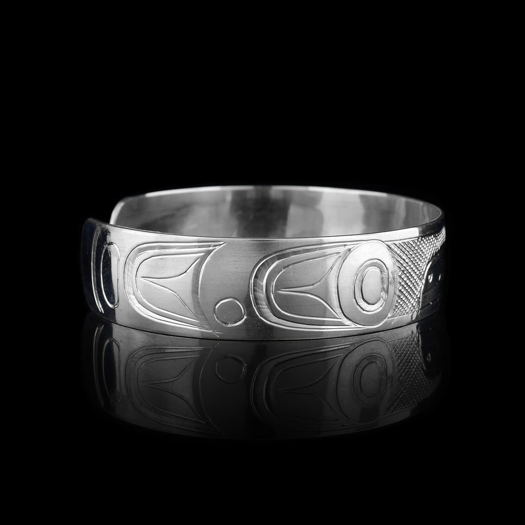 This sterling silver cuff has a single band what a gap in the back. There is a depiction of the Raven carved into the surface of the band.