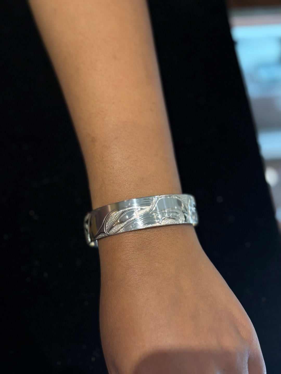 The photo shows a model with their arm at the side and the piece on the wrist.