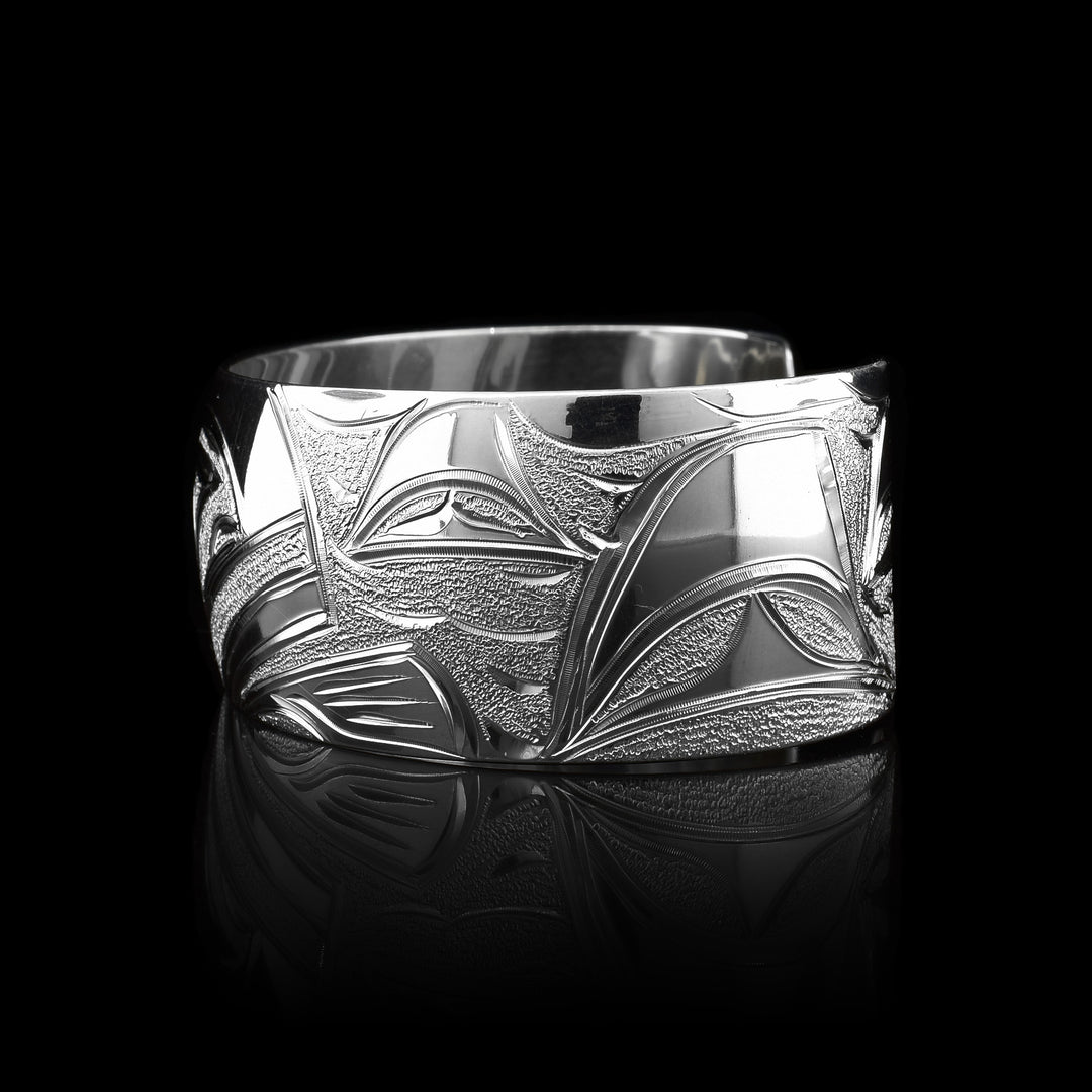 This Orca bracelet cuff has been made using sterling silver and has a single, wide band with a gap in the back. There is a gorgeous depiction of the face of the Orca and it fin carved into the center of the band. There are dorsal fins in the sea depicted on the one side of the band.
