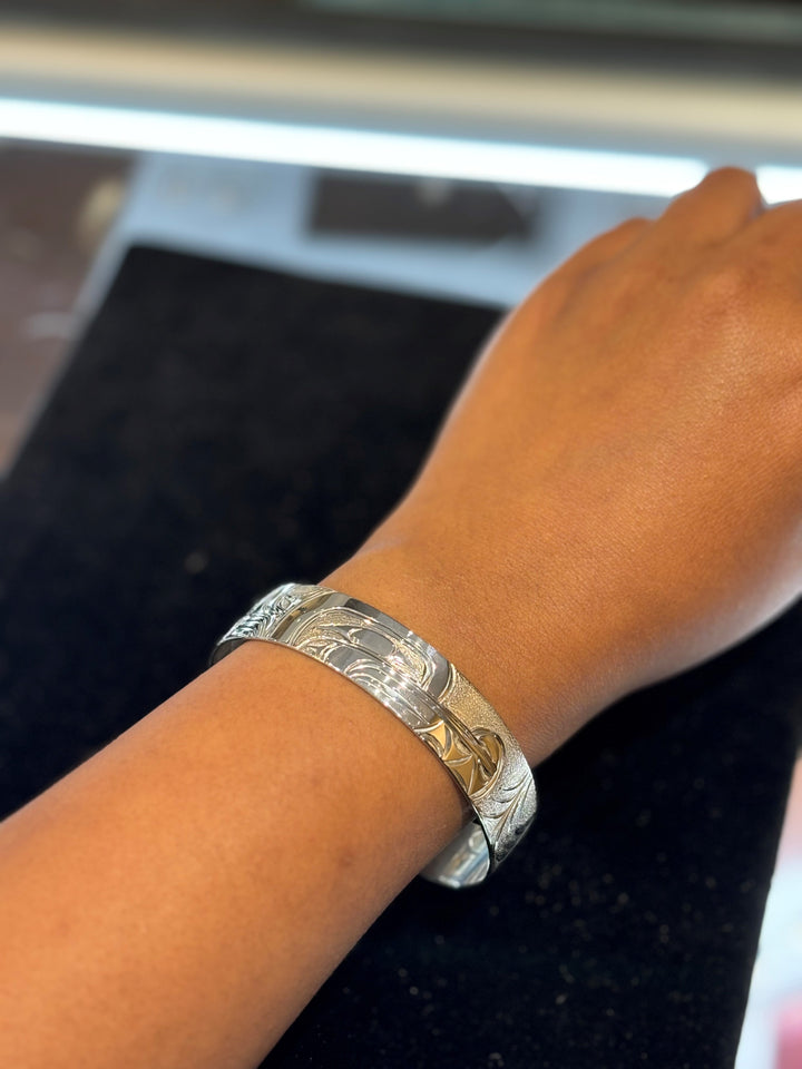 The photo shows a close up of a model's writs and hand while wearing the piece.