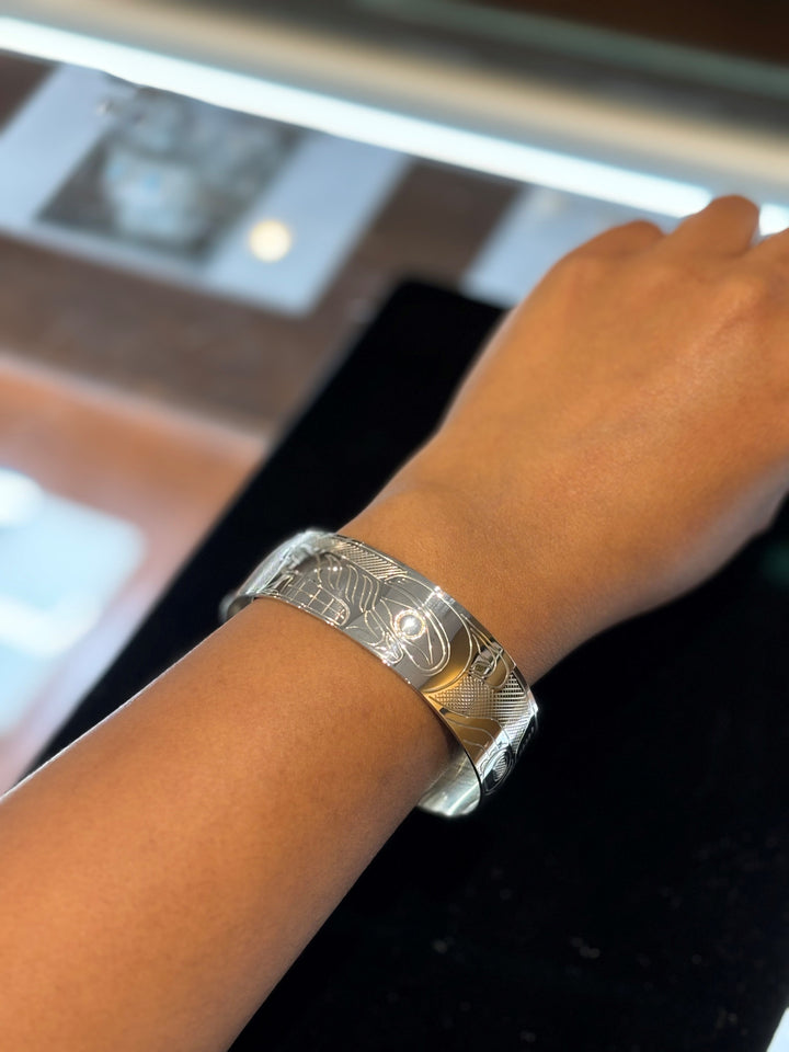 The photo shows a close up of the models wrist wearing the piece.