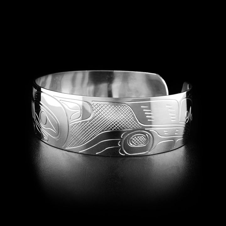 Right angle photo of the bracelet shows carved designs representing the body and paws of the wolf.
