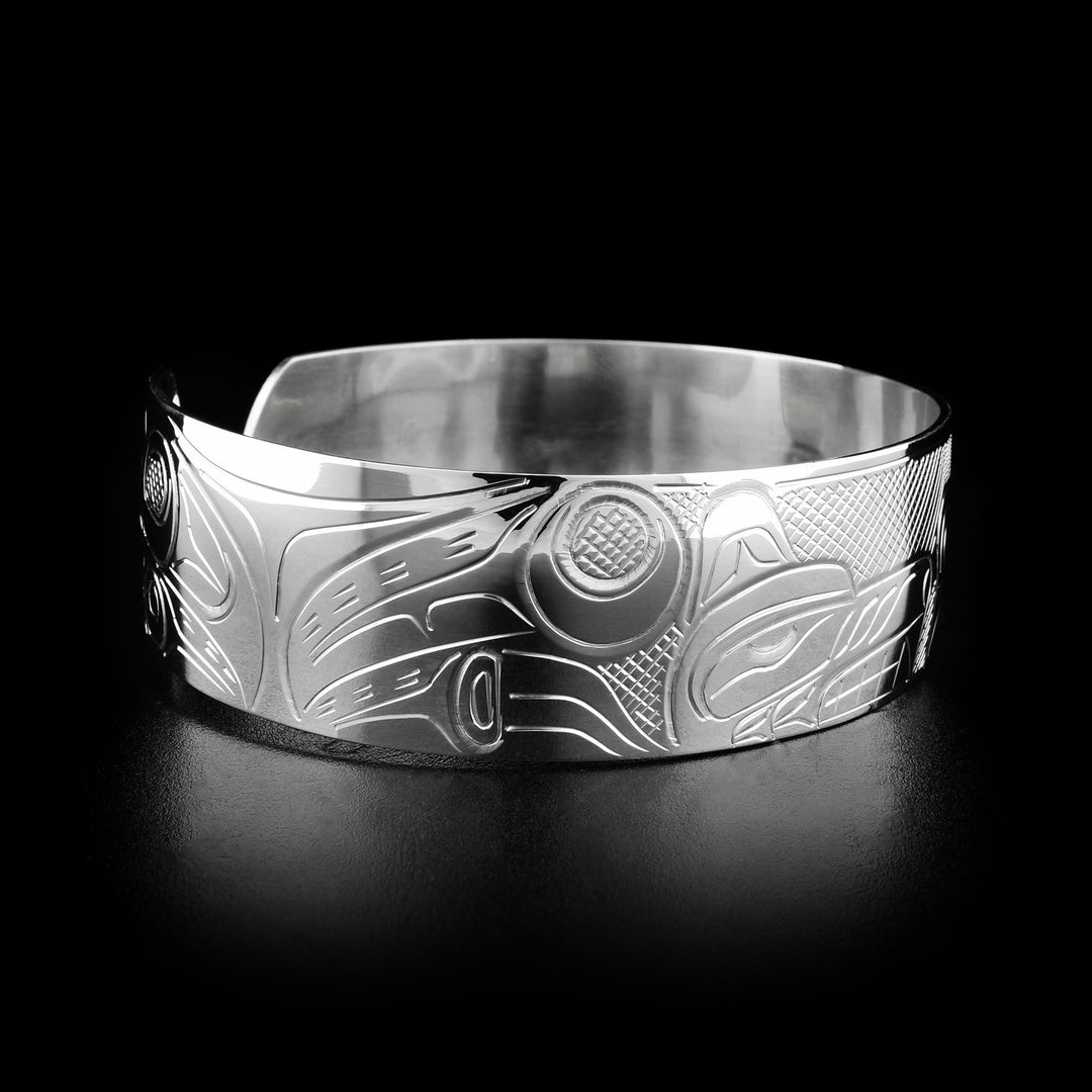 Left angle photo of the bracelet shows carved designs representing the body and paws of the wolf.