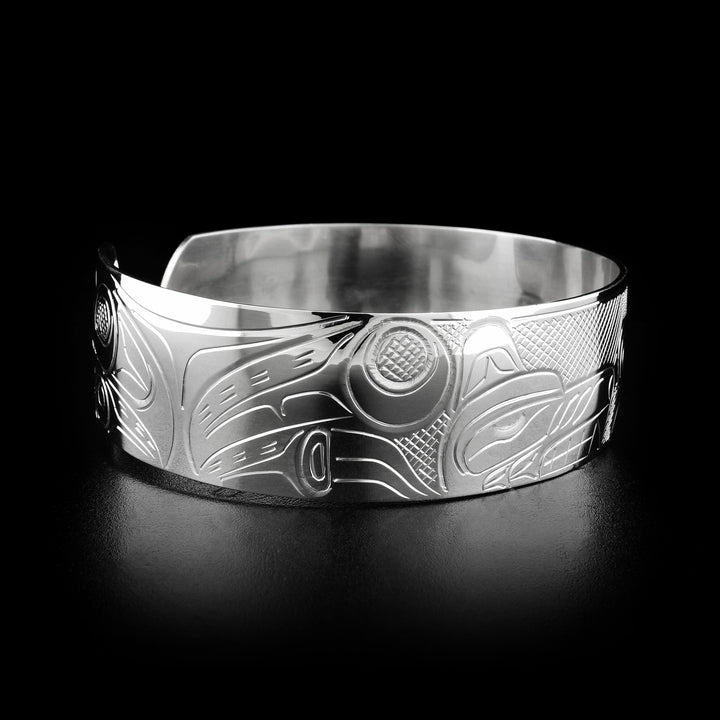 Left angle photo of the bracelet shows carved designs representing the body and paws of the wolf.