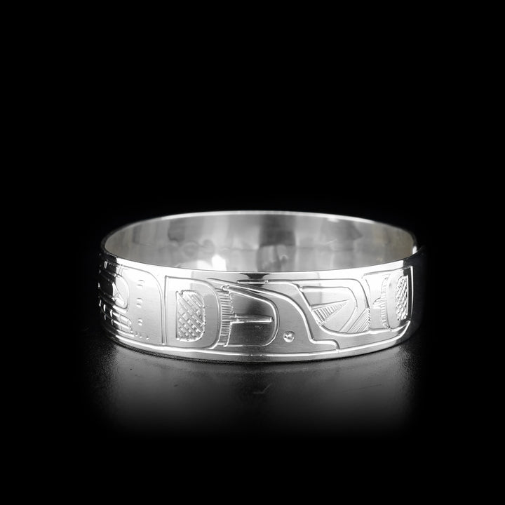 This sterling silver clasp bracelet has depictions of the Orca, the Eagle, and the Sun carved into the band. The Sun is at the top of the band and there is a clasp in the back.