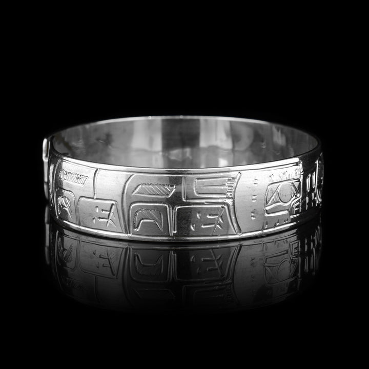 This Wolf and Moon bracelet is made from sterling silver. There are two depictions of the Wolf and a depiction of the Moon carved into the band. The two Wolves are depicted facing the Moon.