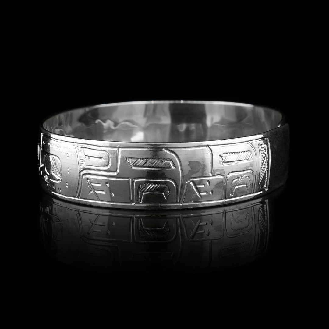 This Wolf and Moon bracelet is made from sterling silver. There are two depictions of the Wolf and a depiction of the Moon carved into the band. The two Wolves are depicted facing the Moon.