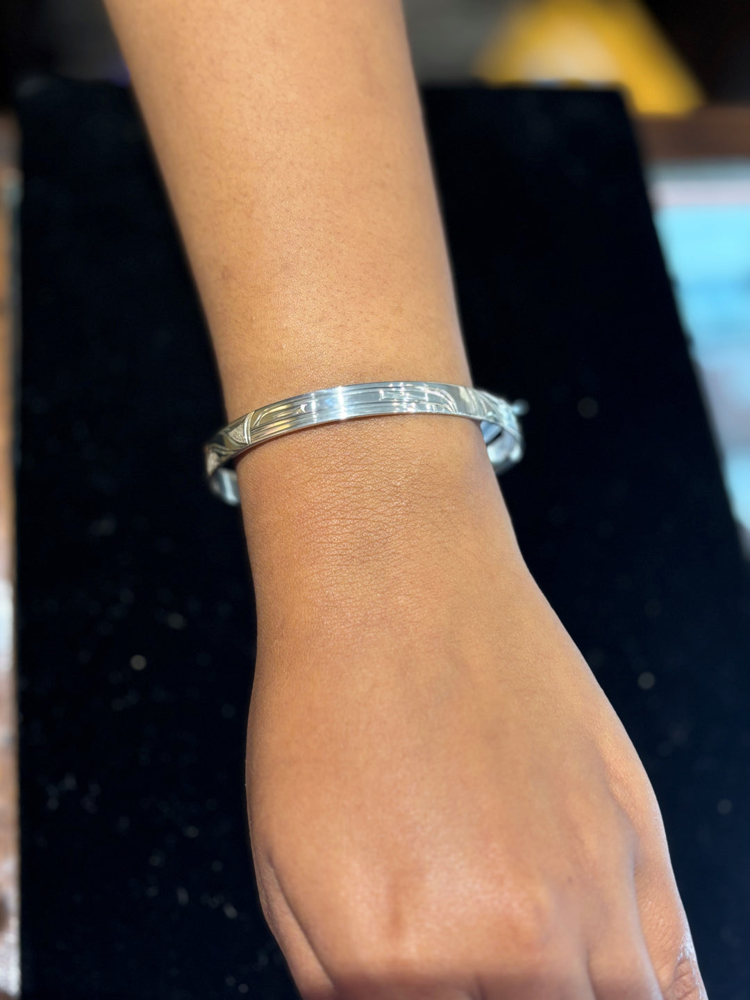 The photo shows a close up of the models wrist with the piece on it.