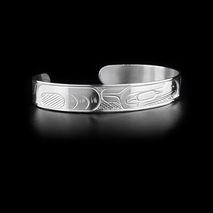 This sterling silver cuff bracelet has a thin band with a depiction of the Eagle carved into the surface of it.