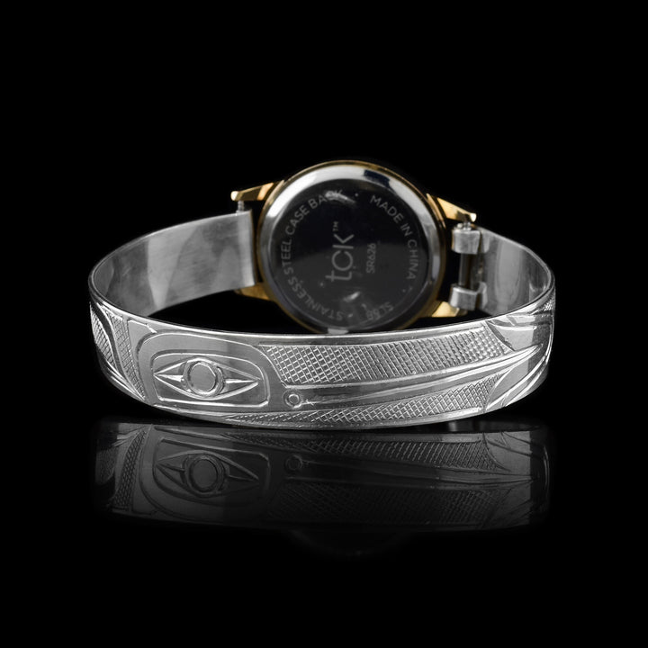 This sterling silver watch with a golden colored face has a band with depictions of the Hummingbird carved into it. The face of the watch is made from stainless steal.