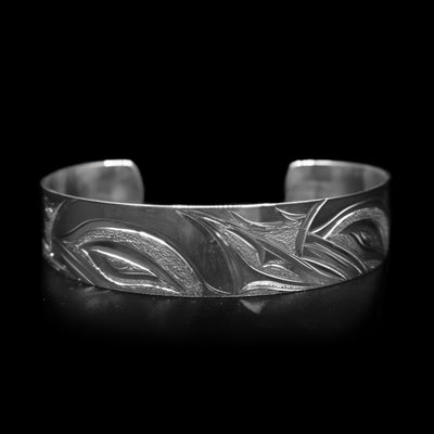 This Orca whale bracelet has a single, sterling silver band with a gap in the back. There are depictions of Orca whales beautifully carved into the surface if the band.