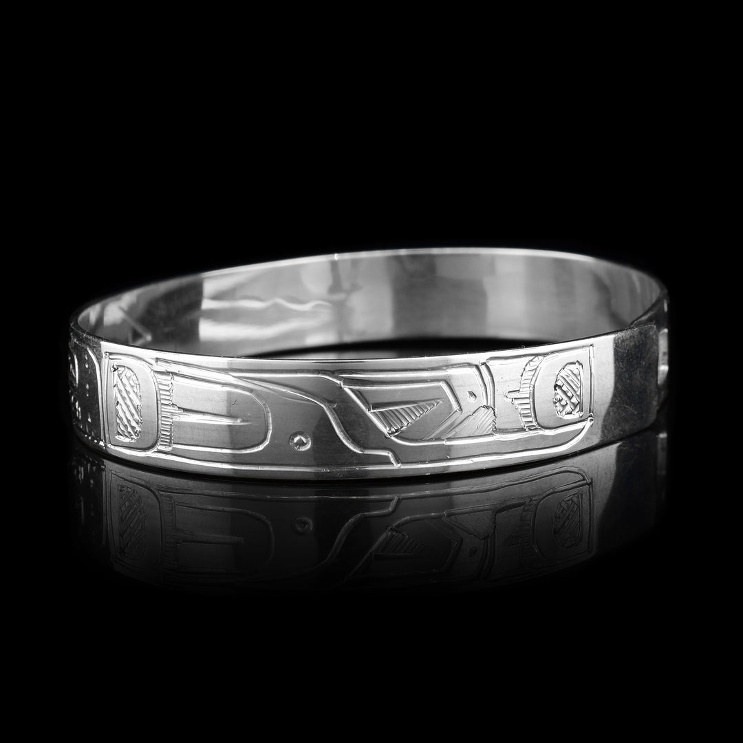 This Hummingbird, Orca and Sun bracelet has a single, sterling silver band with a clasp in the back. There is a depiction of the Sun in the center of the band positioned between the Hummingbird and the Orca. The legends are beautifully carved into the surface of the band.