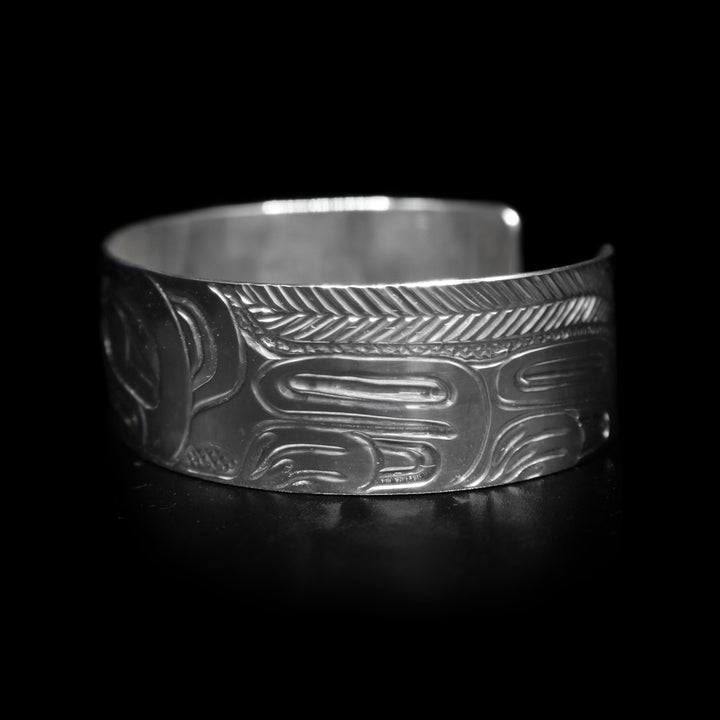 This Wolf and Moon bracelet has a single, wide and sterling silver band with a gap in the back. There is a depiction of the Wolf and the Moon legends carved into the band.