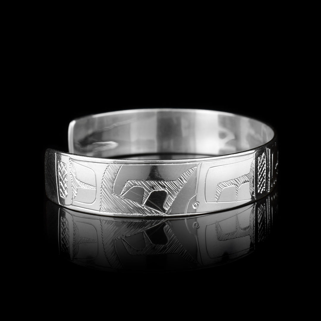 This sterling silver cuff bracelet has a single band with a depiction of the Orca carved into it.