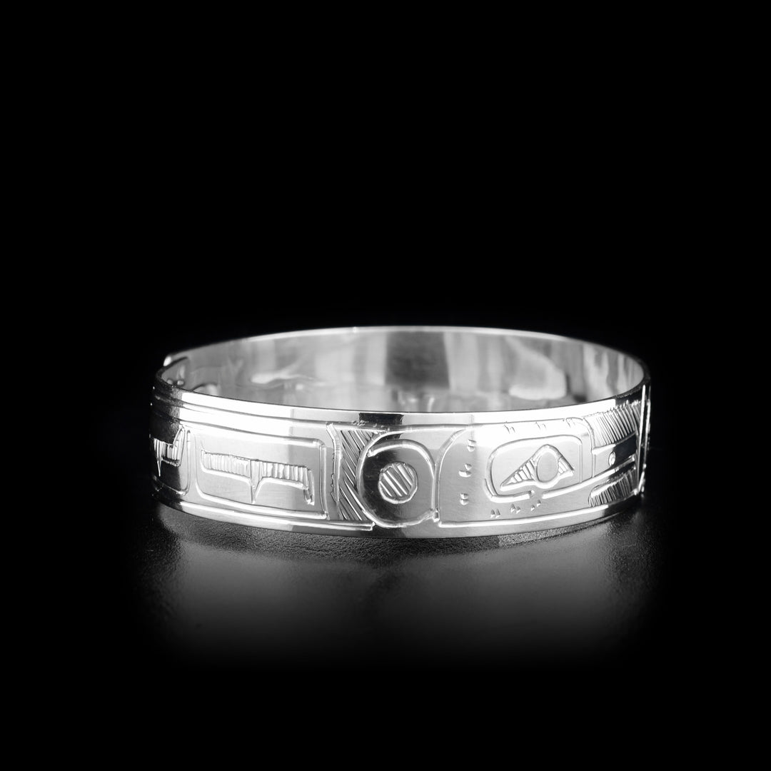 This sterling silver clasp bracelet has two depictions of the Hummingbird and a depiction of the Sun carved into the band. The Hummingbirds are depicted facing the Sun and there is a clasp at the back of the bracelet.