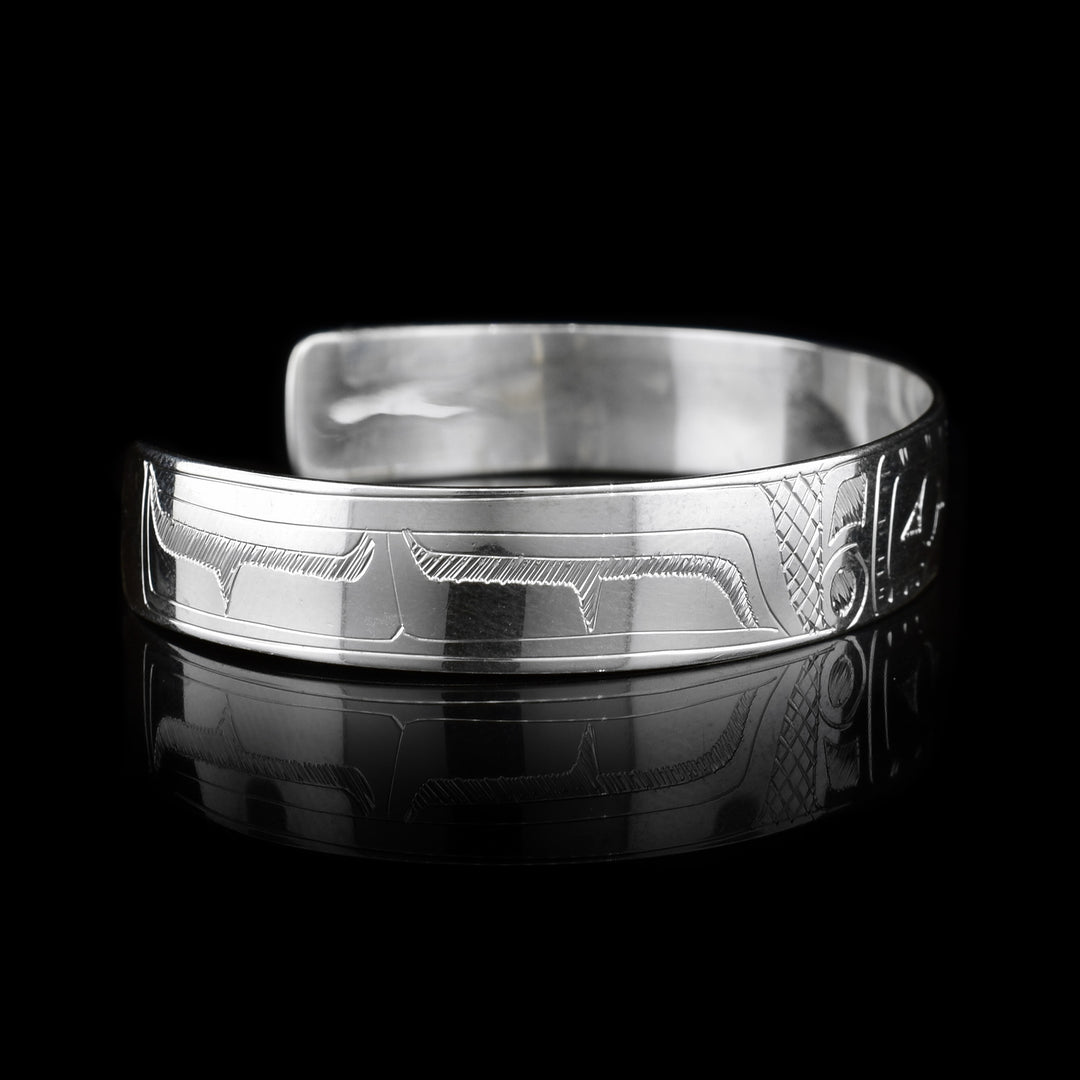 This sterling silver cuff bracelet has a thin band with a depiction of the Hummingbird carved into the surface of it.