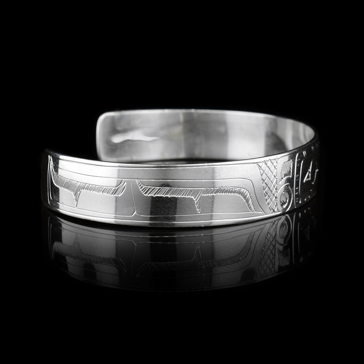 This sterling silver cuff bracelet has a thin band with a depiction of the Hummingbird carved into the surface of it.