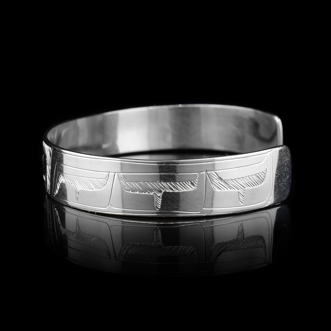 This sterling silver cuff bracelet has a thin band and there is a depiction of the Eagle carved into the surface of it.