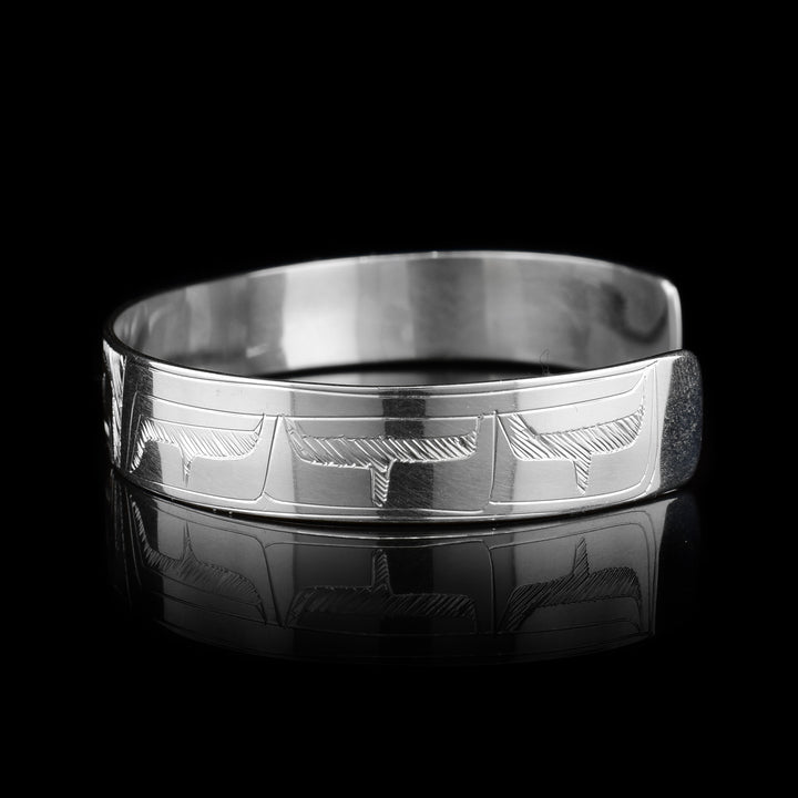 This sterling silver cuff bracelet has a thin band and there is a depiction of the Eagle carved into the surface of it.