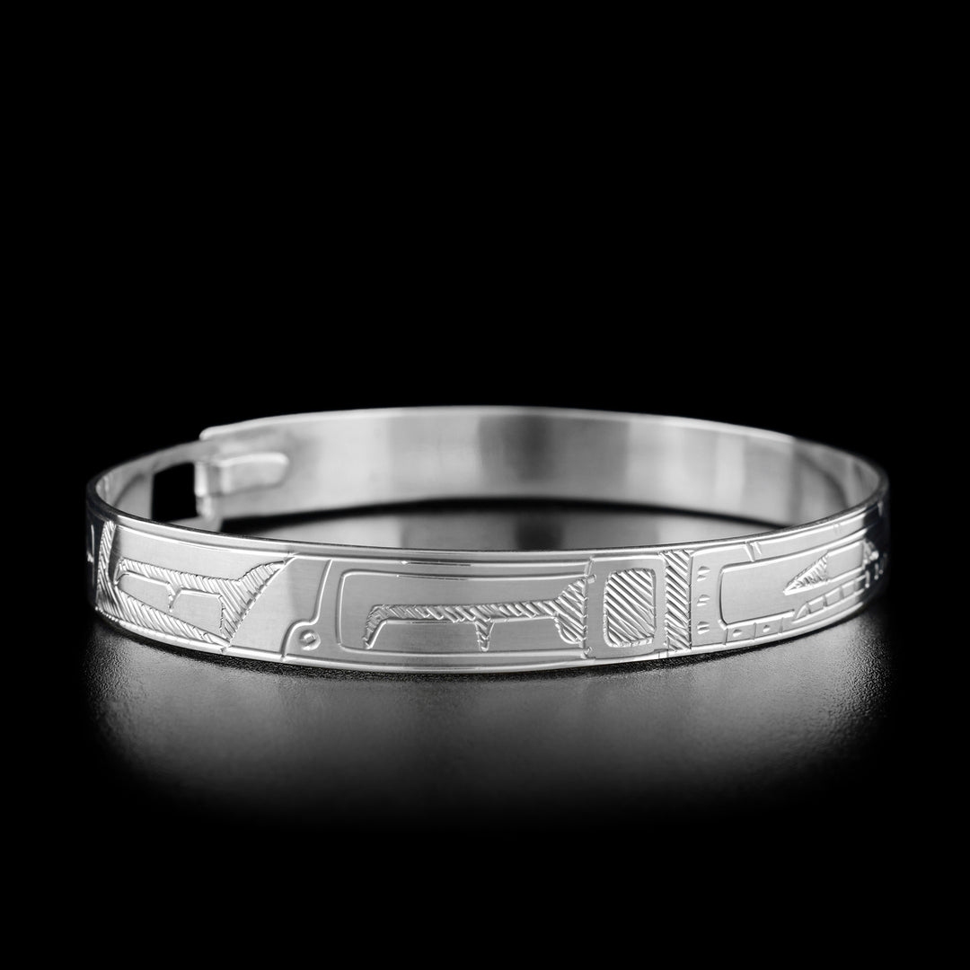 Left angle photo of the bracelet shows carved designs representing the body and fins of the orca. Both sides are identical.