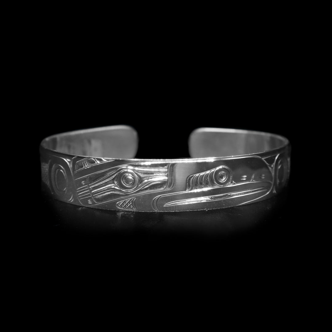 This sterling silver cuff bracelet has a single band with a gap in the back. There is a depiction of the Raven that has been beautifully carved into the surface of the band.