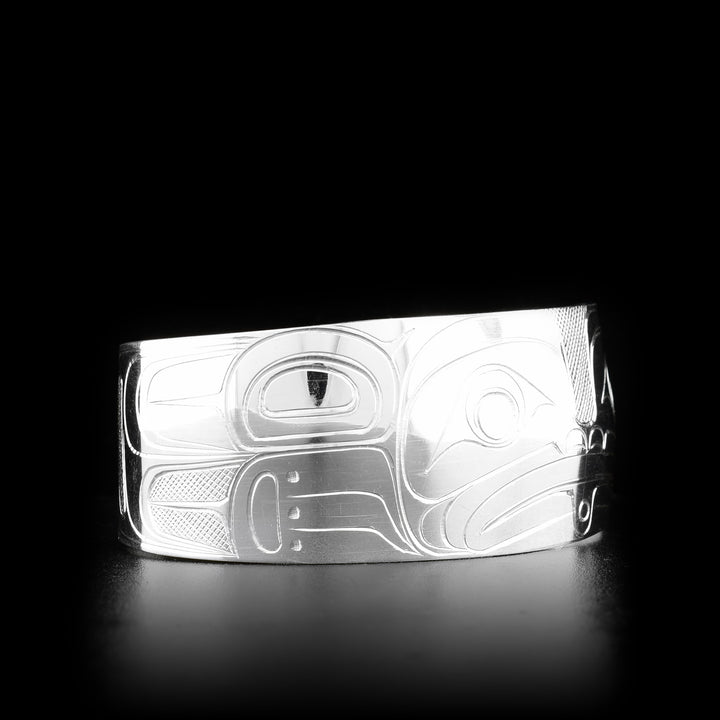 This Frog bracelet is made from sterling silver and has a wide band that tapers slightly. There is a depiction of the Frog carved into the surface of the band.